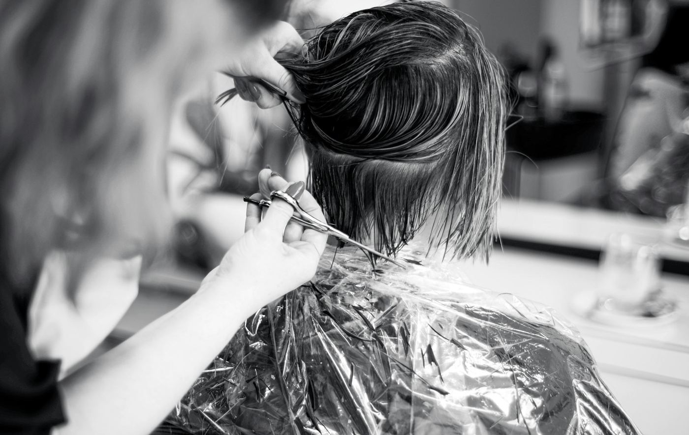A stylist foiling a client's hair for highlights